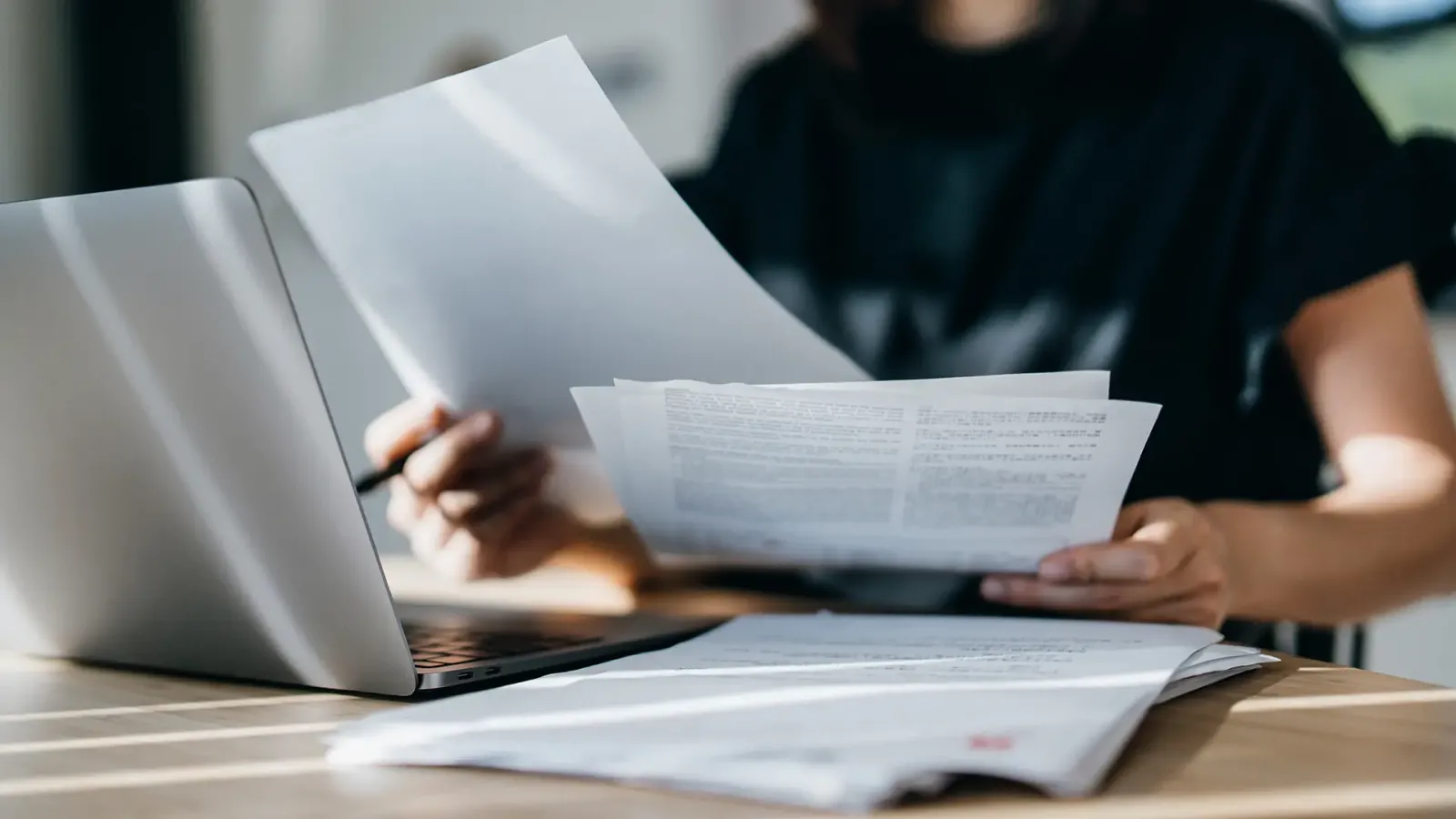 woman with papers and laptop